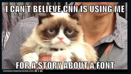 a popular internet meme featuring grumpy cat being held, the text overlay reads, i can't believe cnn is using me for a story about a font, humorously referencing the impact font commonly used in memes