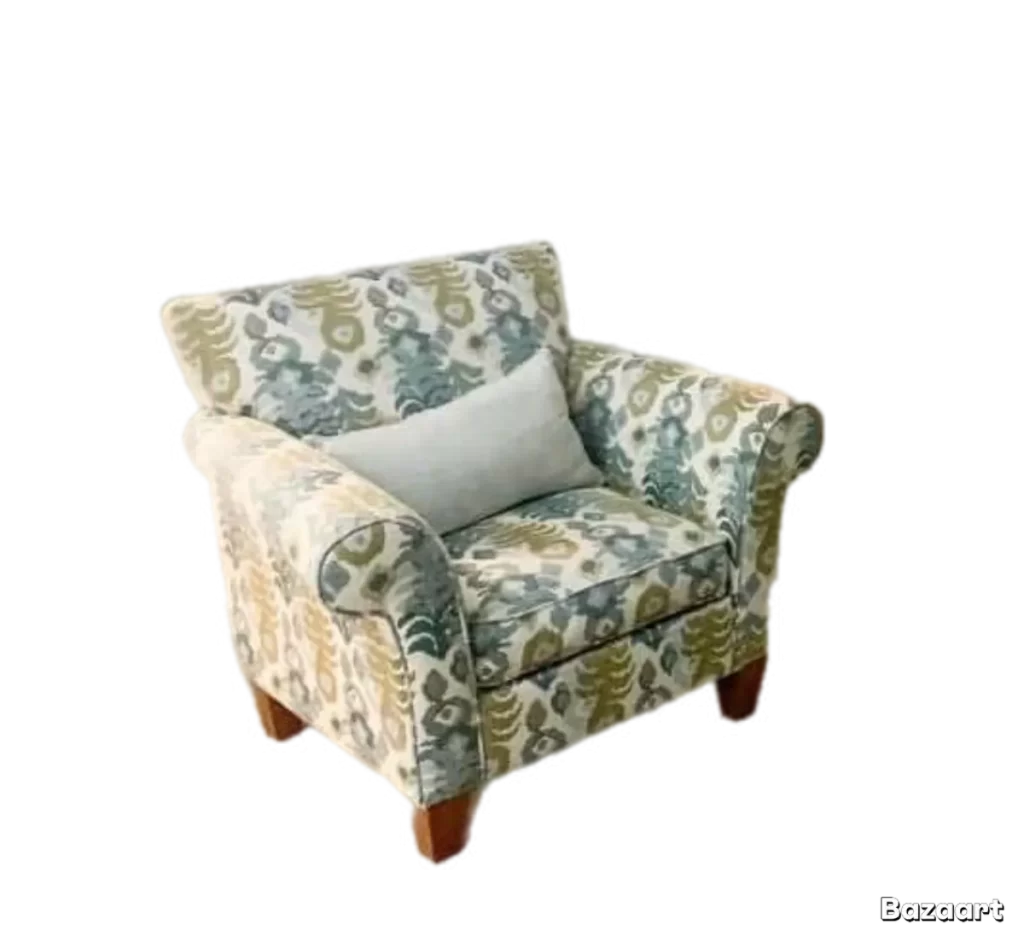 the same armchair with a blue, green, and cream floral pattern and a light grey pillow, isolated on a transparent background with a bazaart logo in the bottom right corner
