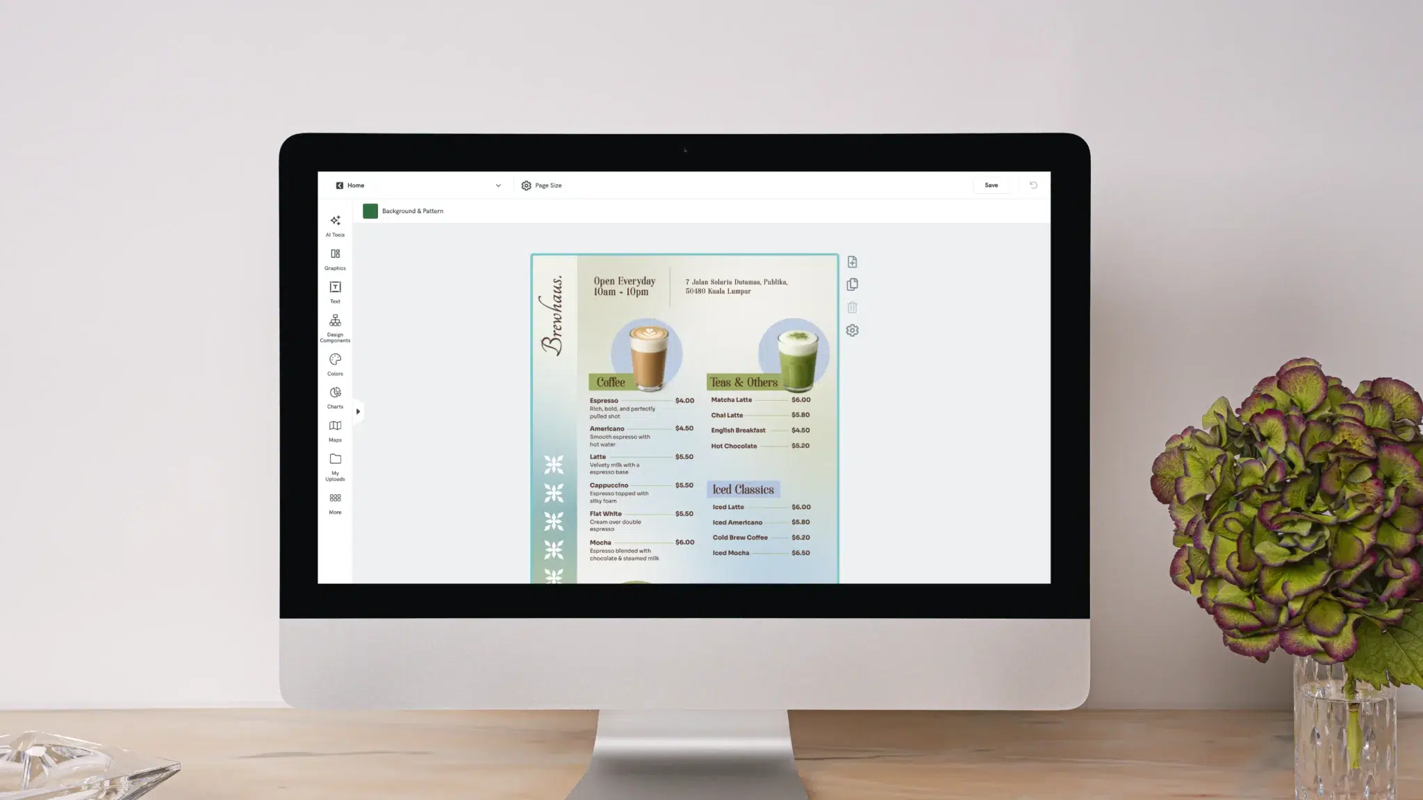 computer monitor displaying a design software interface for a coffee shop menu titled brewhaus, the menu is divided into sections for coffee, teas, and iced classics, a potted hydrangea plant sits to the right of the monitor